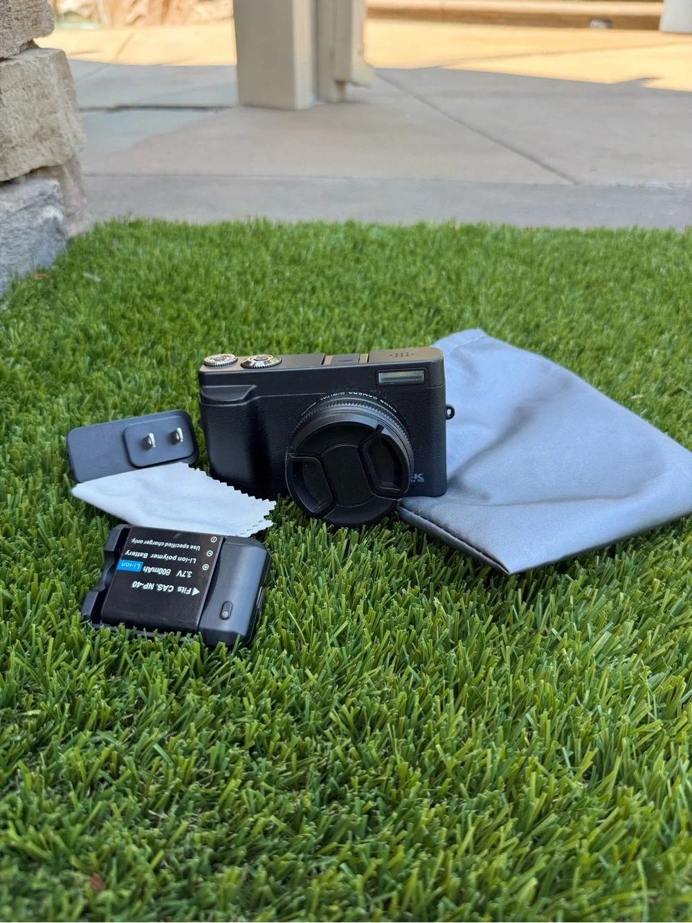Compact Black Digital Camera with Accessories and Lens Cap